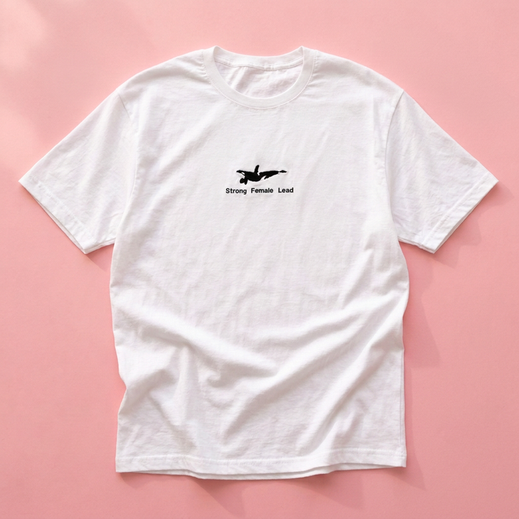 Flat lay with only the Orca tee on pink