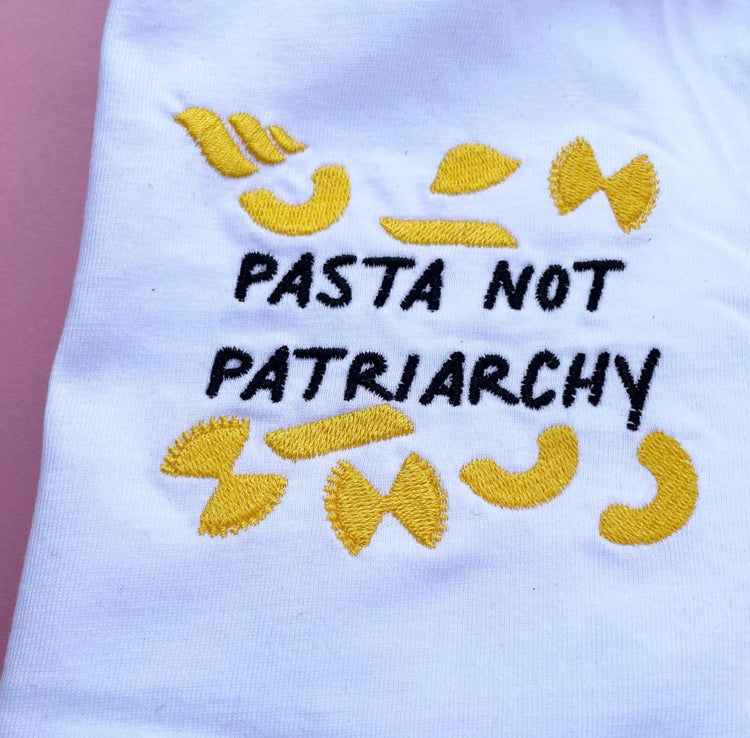 Close up of yellow pasta embroidery on the Pasta Not Patriarchy tee
